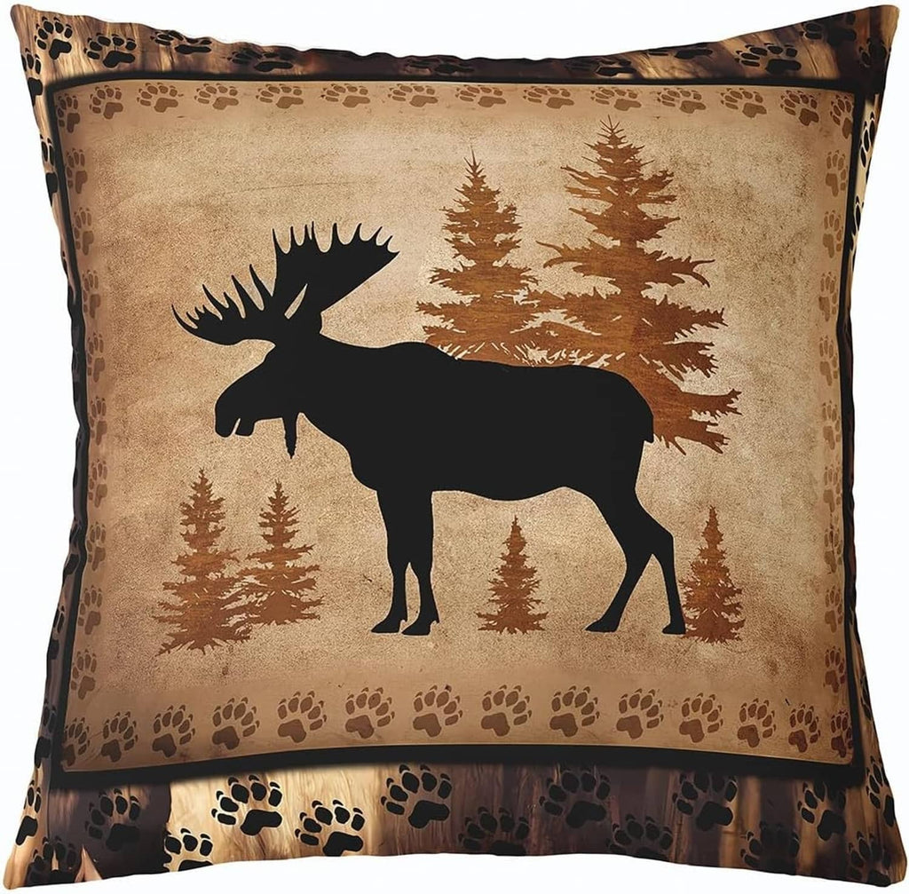 Tan throw pillow cover with black moose silhouette among pine trees and paw print border