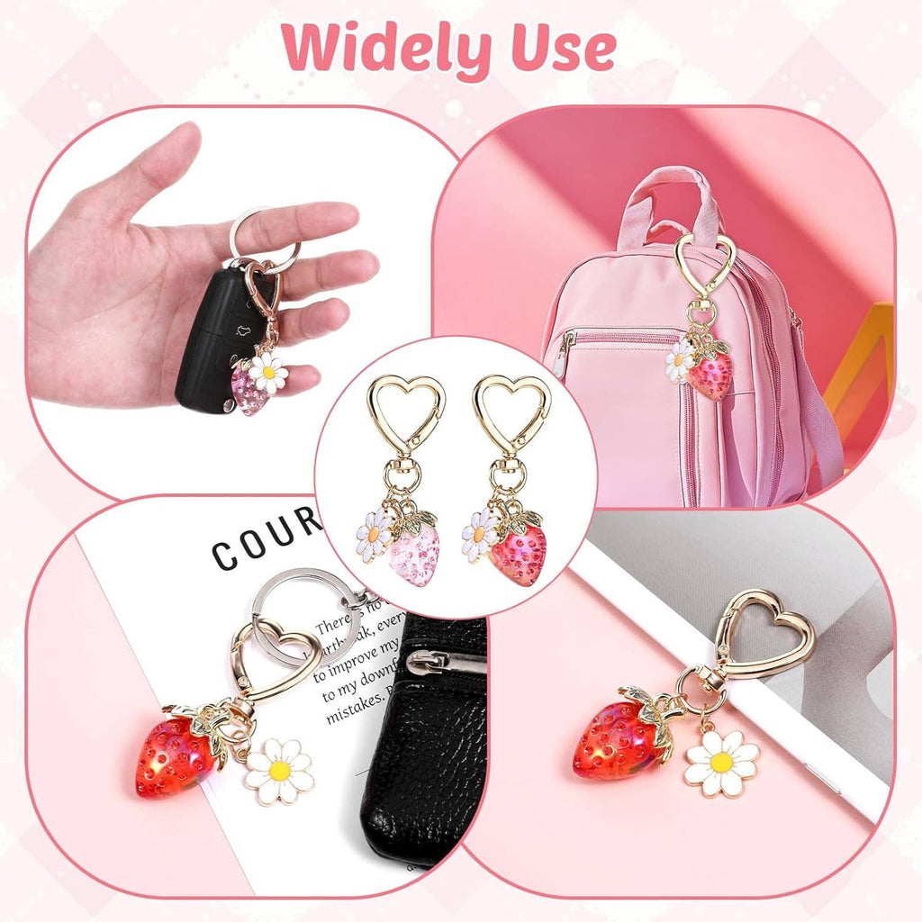 Gold heart keychain pair with strawberry charms and white daisies for attaching to bags or keys