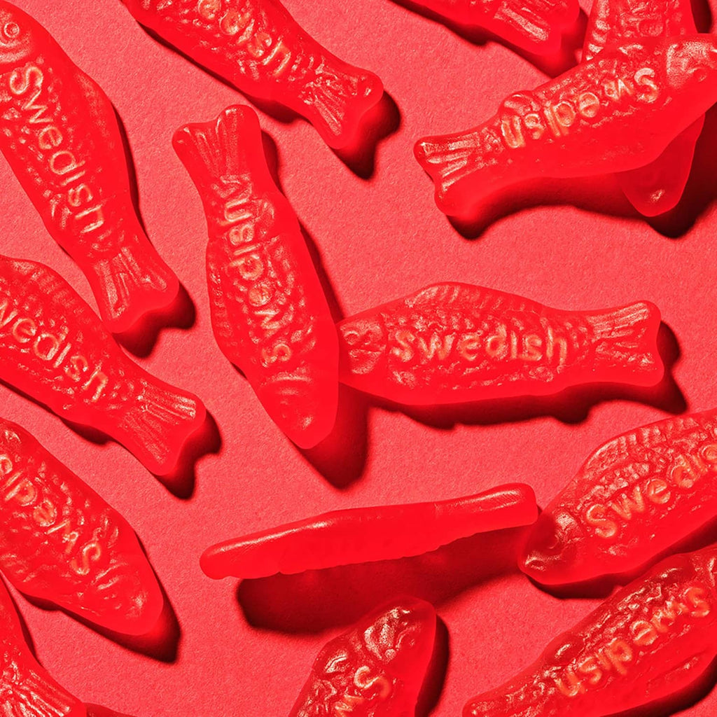 Close-up of red gummy fish candies with embossed details