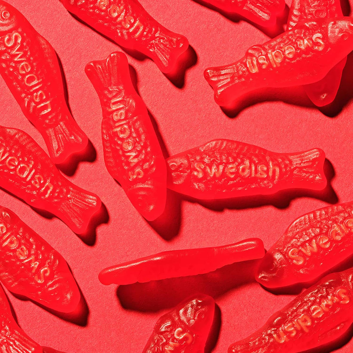 Close-up of red gummy fish candies with embossed details