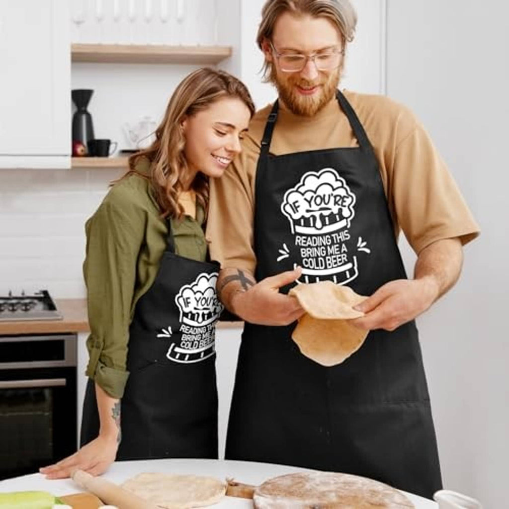 Black BBQ apron with beer quote logo, worn over a tan shirt