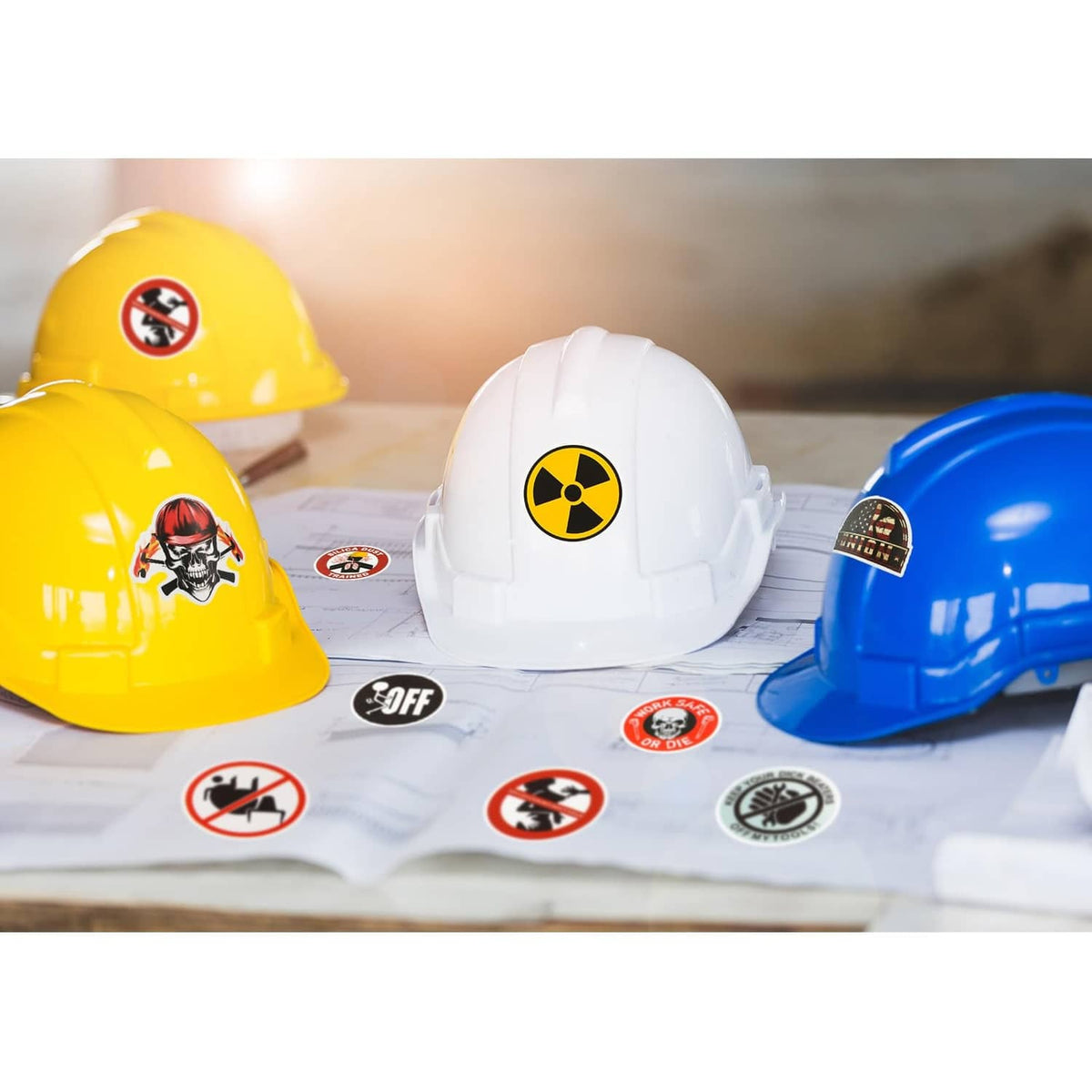 Yellow, white, and blue hard hats covered with safety and hazard sticker decals