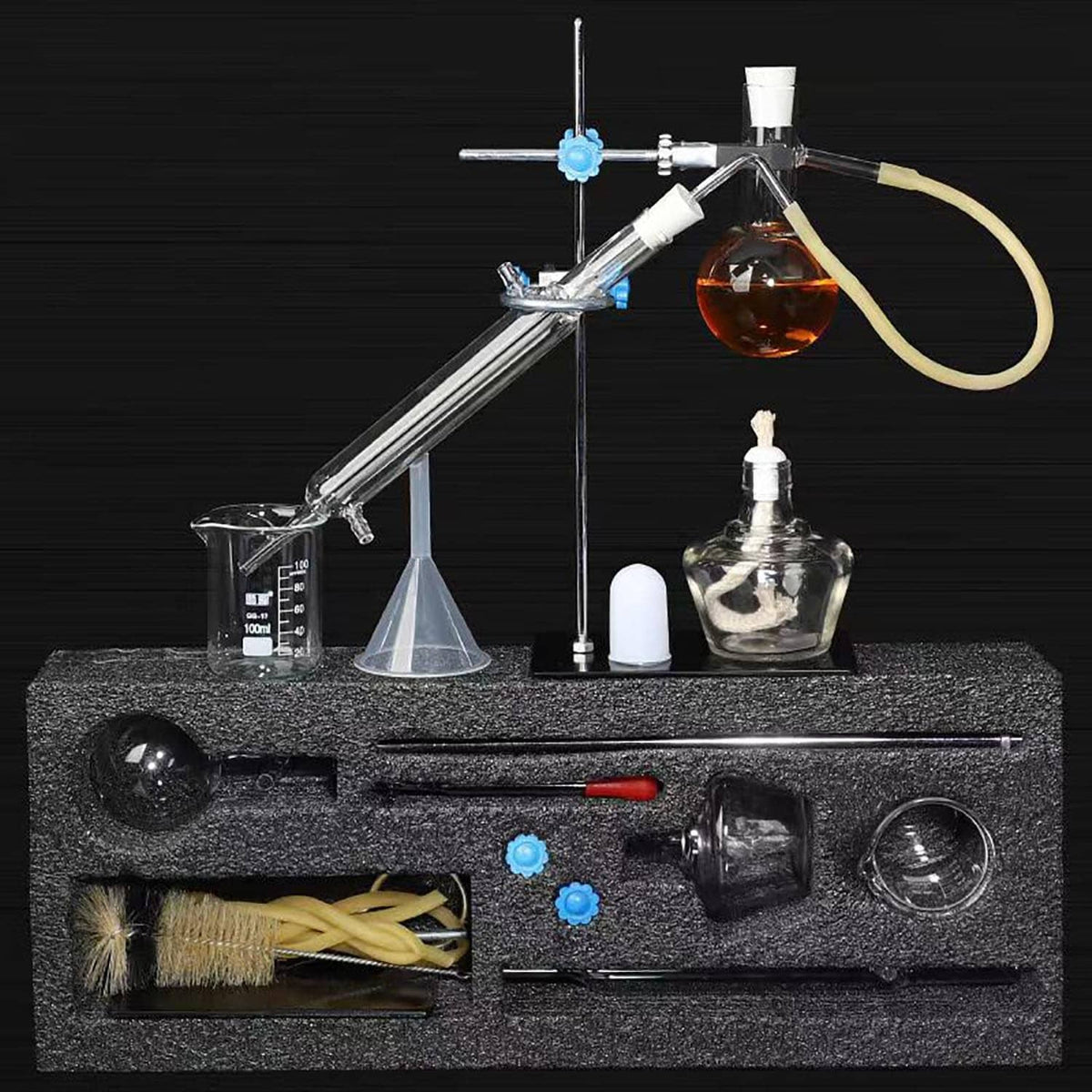 Distillation apparatus on a base with thermometer, glass beaker, tubing, and receiving flask