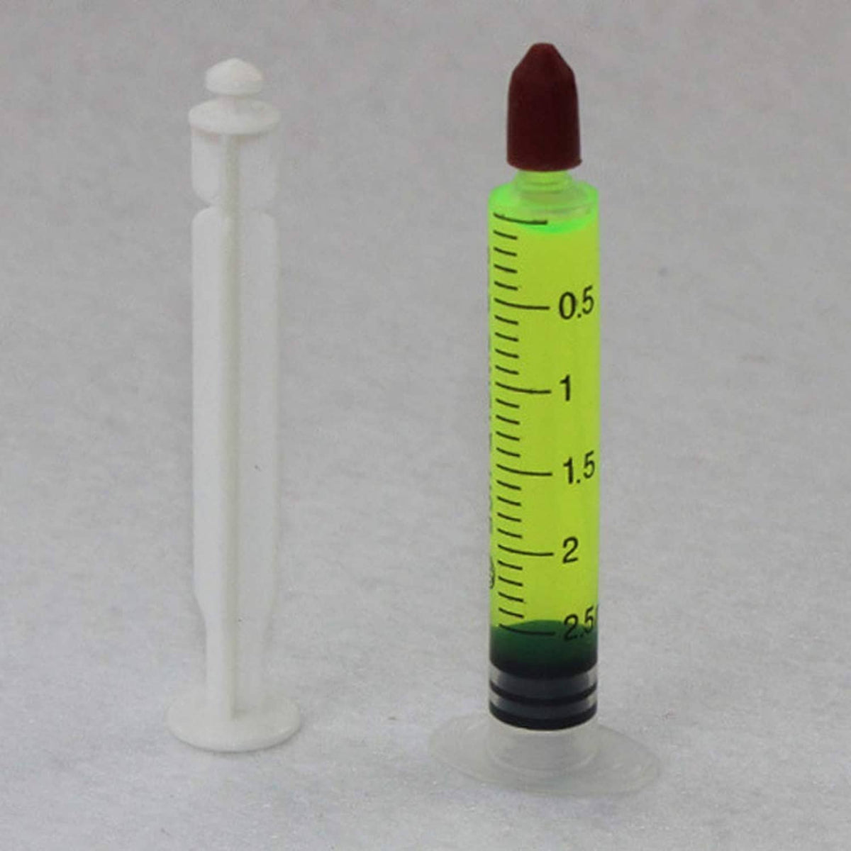 Leak detector syringes: white plunger syringe and green measurement syringe