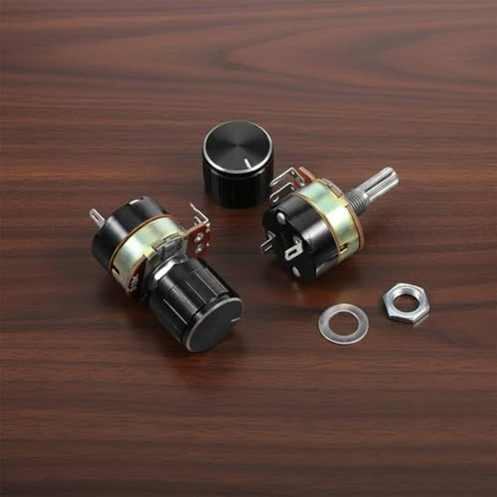Two black dimmer potentiometer knobs with silver shafts and mounting nuts on wood