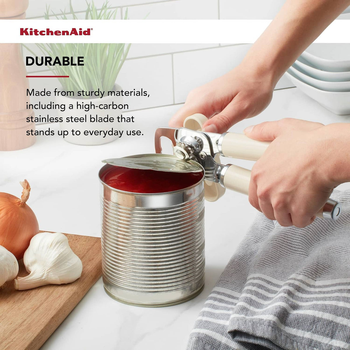 Can opener with almond cream handles cutting into a metal can