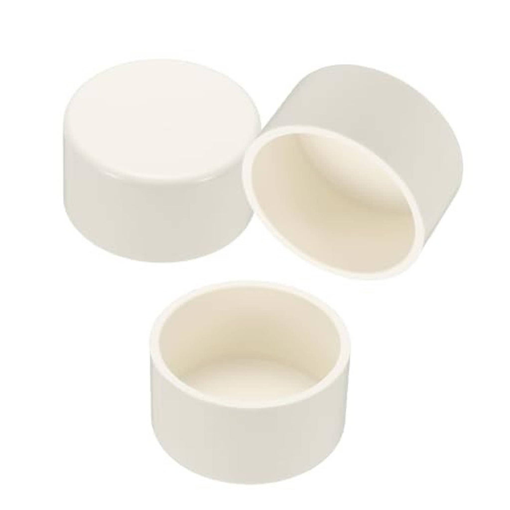 Set of white PVC pipe end cap plugs, 2.5-inch diameter, side view with open ends