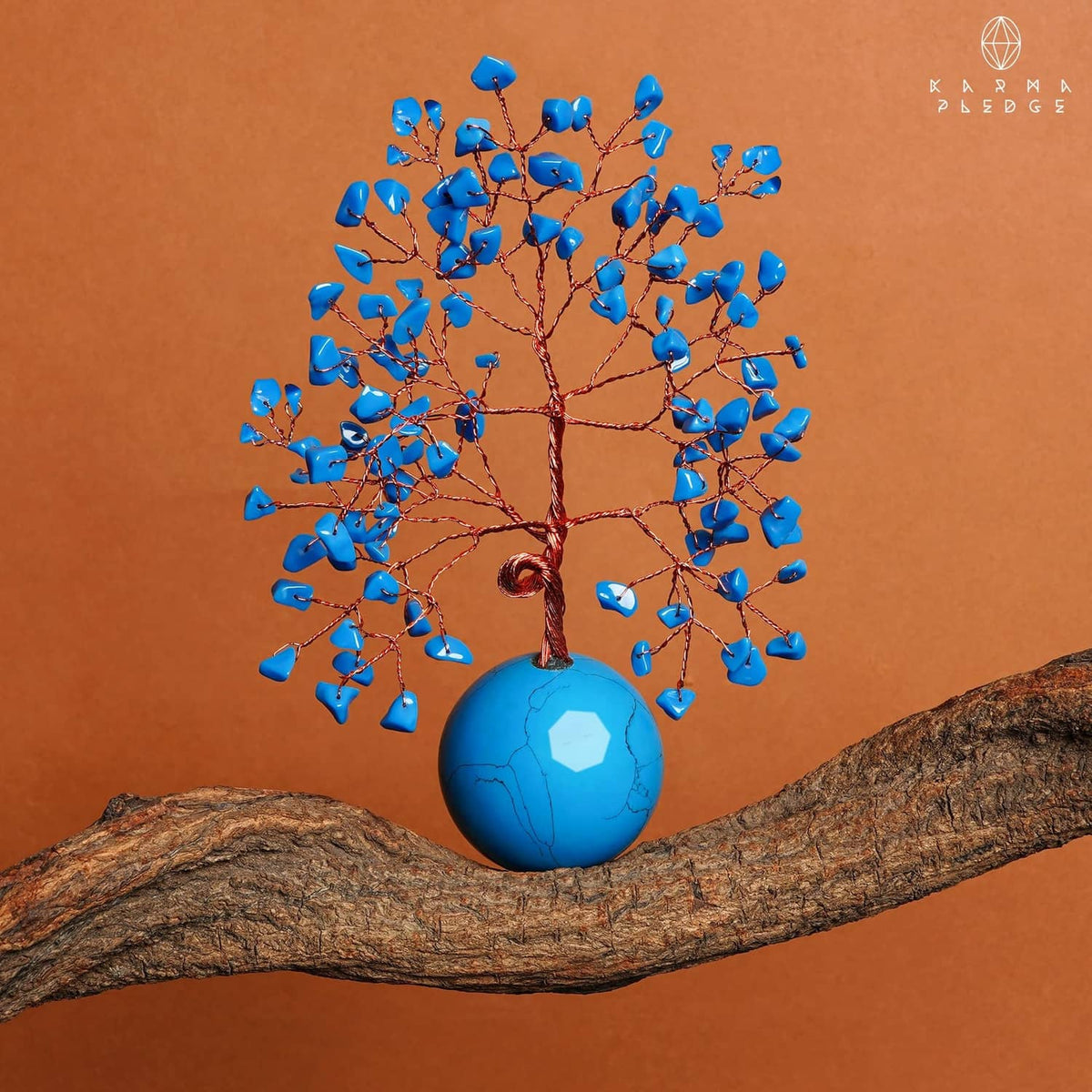 Turquoise ball base Tree of Life ornament with blue crystal leaves on a log display