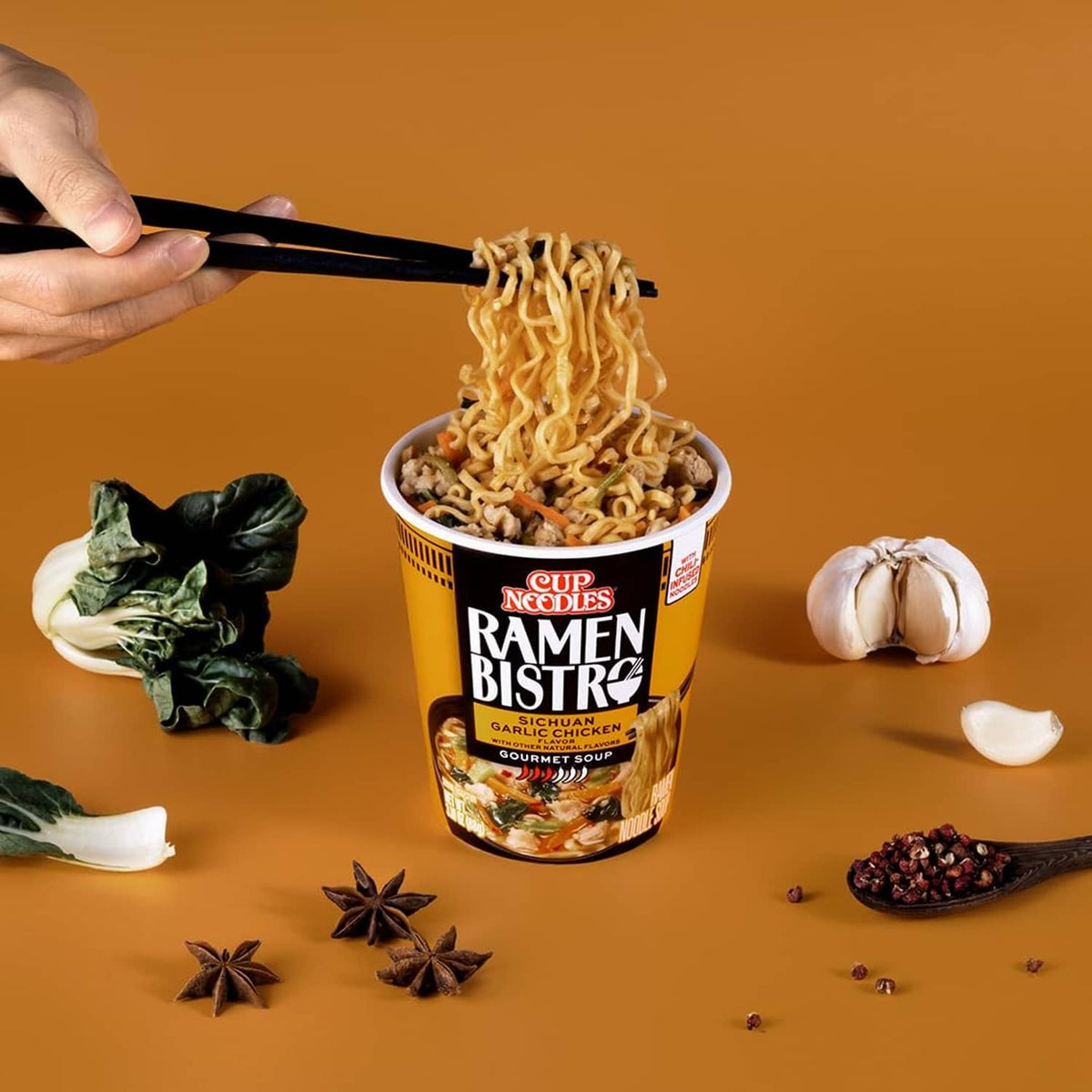 Instant ramen cup with visible noodles, black and orange Ramen Bistro label