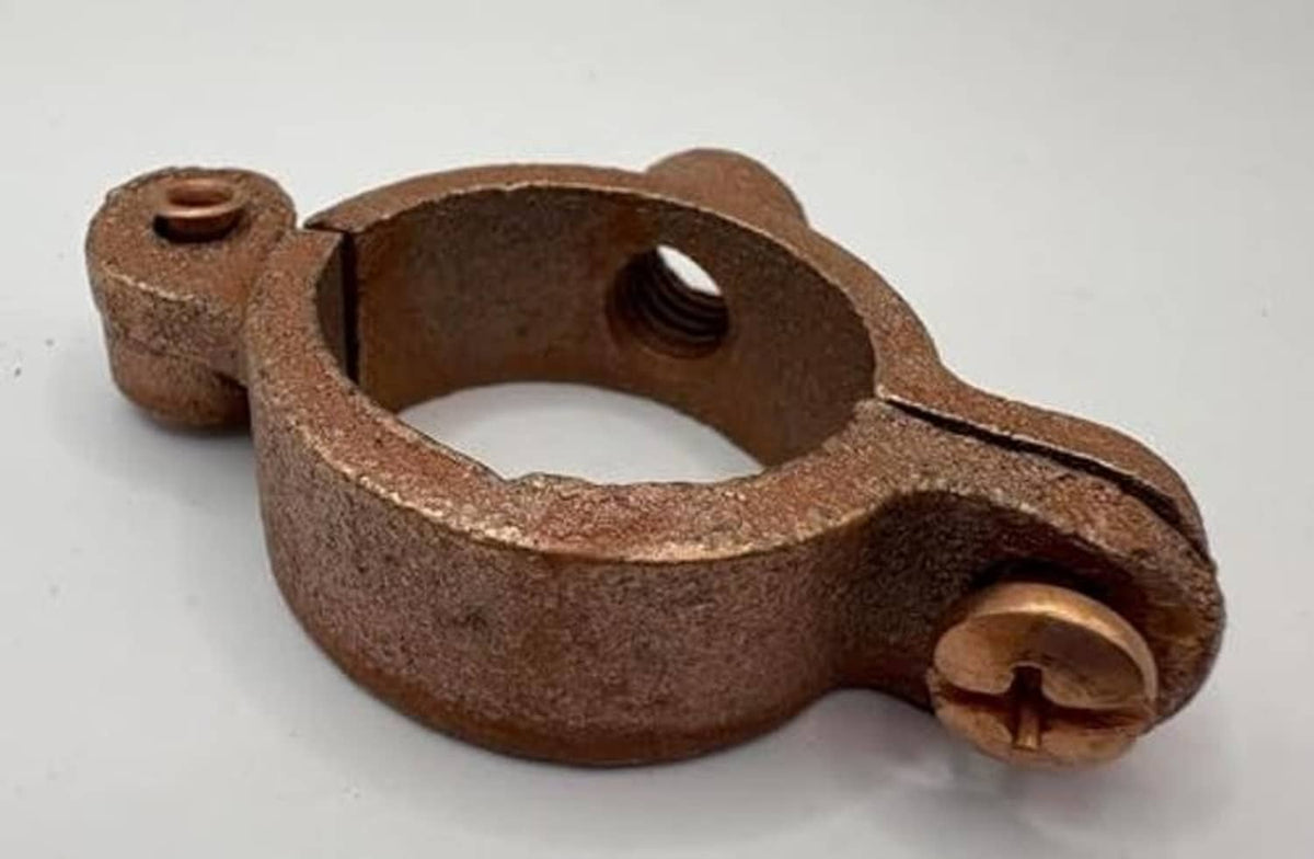 Copper-plated split ring pipe hanger underside with mounting bolt hole and clasp