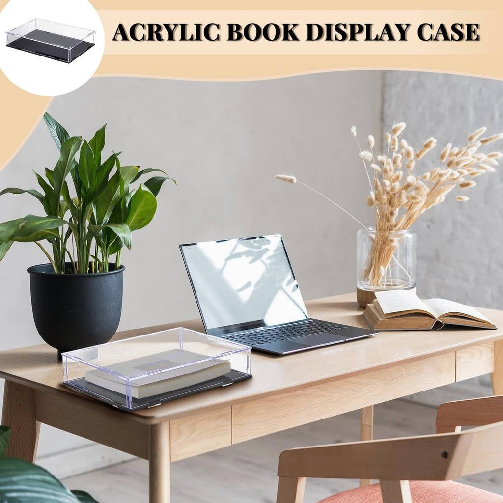 Clear acrylic book display case with black base on a desk