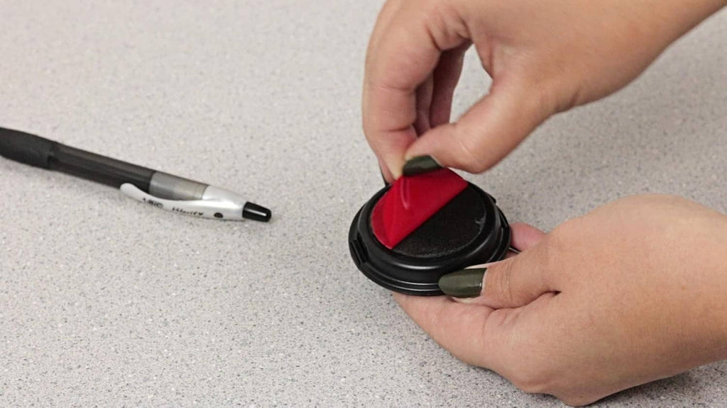 Hands pressing an inkless fingerprint pad onto a fingertip
