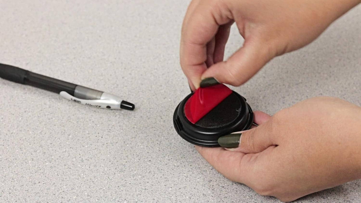 Hands pressing an inkless fingerprint pad onto a fingertip