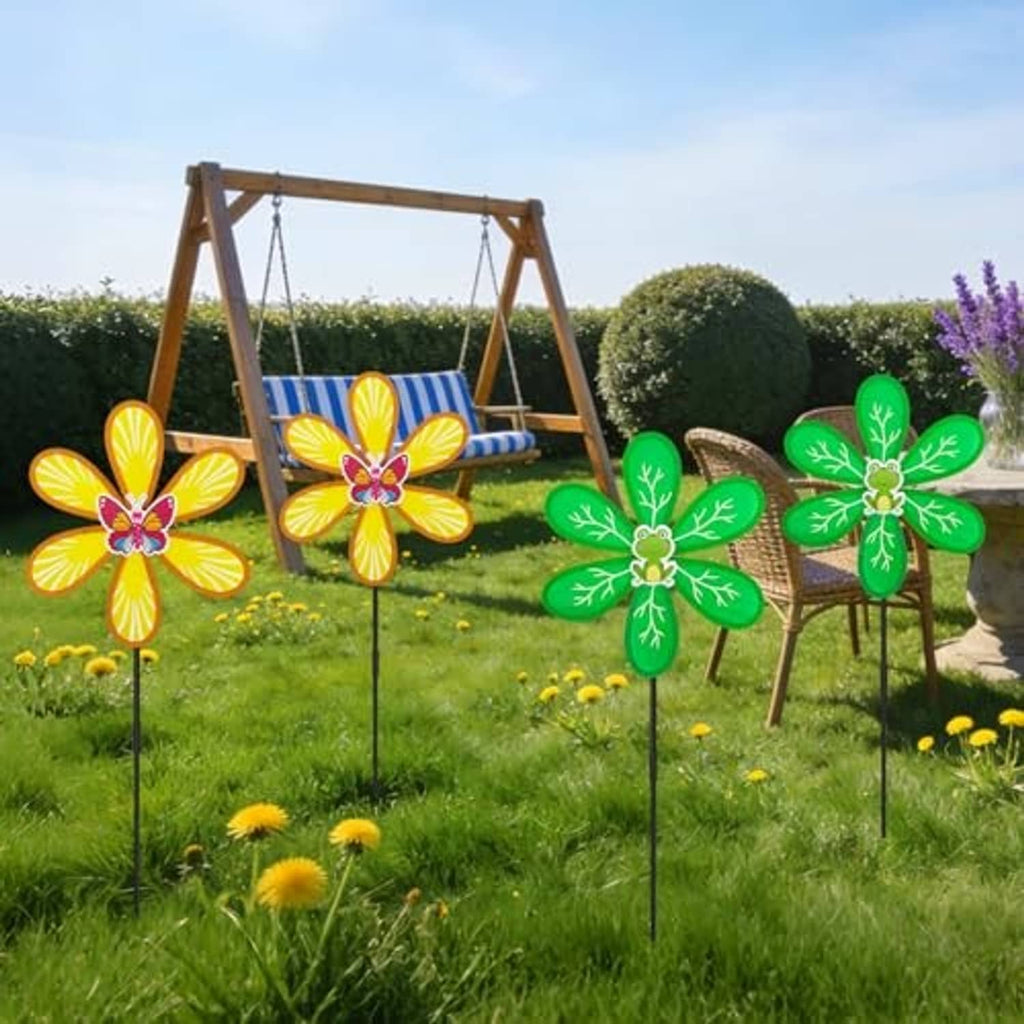 Four outdoor wind spinners with green leaf petals and yellow flower petals on black stakes
