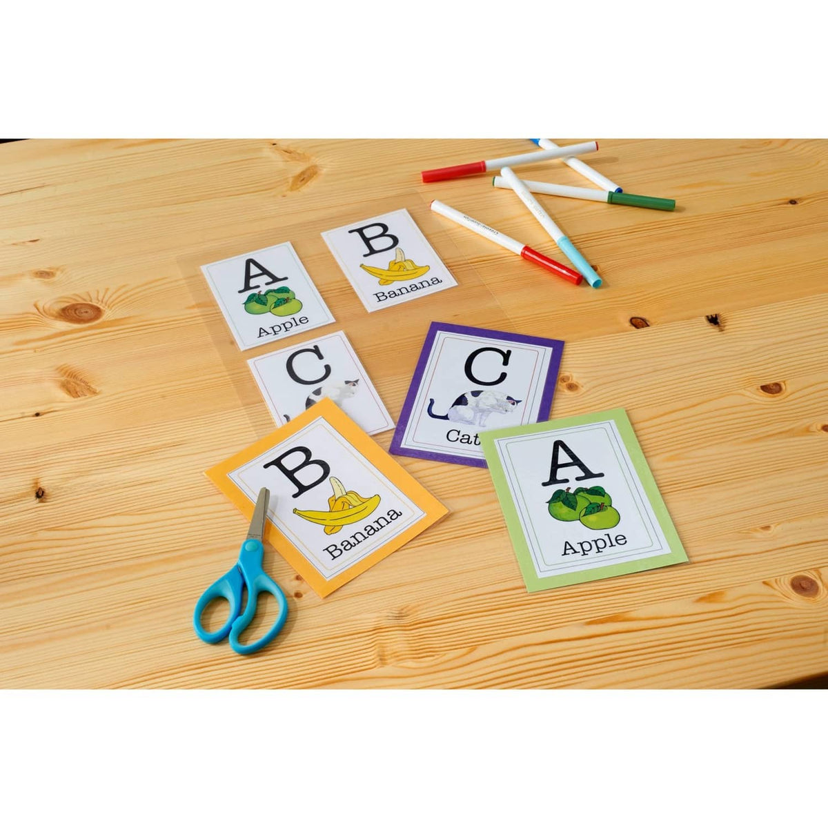 Alphabet flash cards for lamination with crayons on a wooden surface