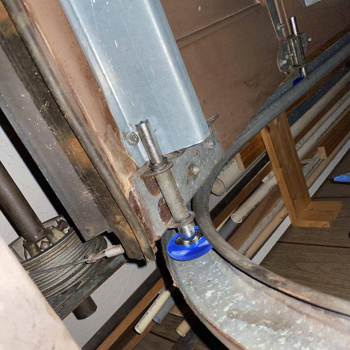 Blue sealed garage door roller in track with silver stem