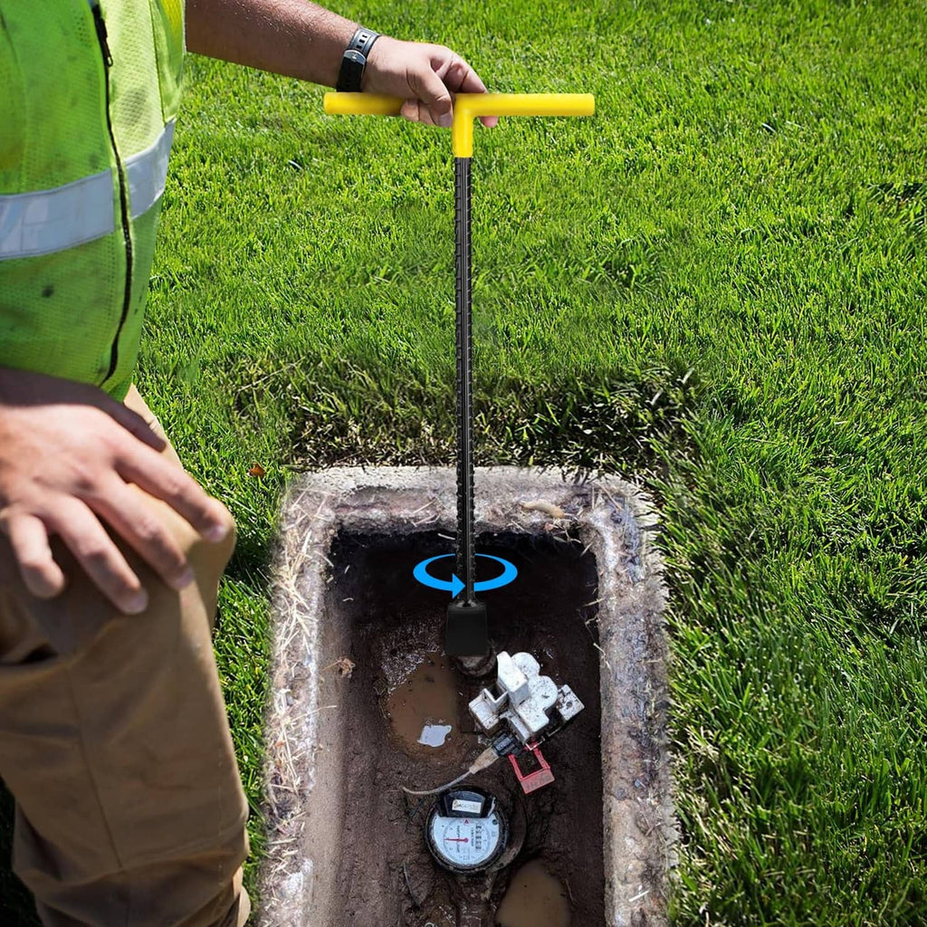 Water meter shut-off key held above an outdoor valve box opening