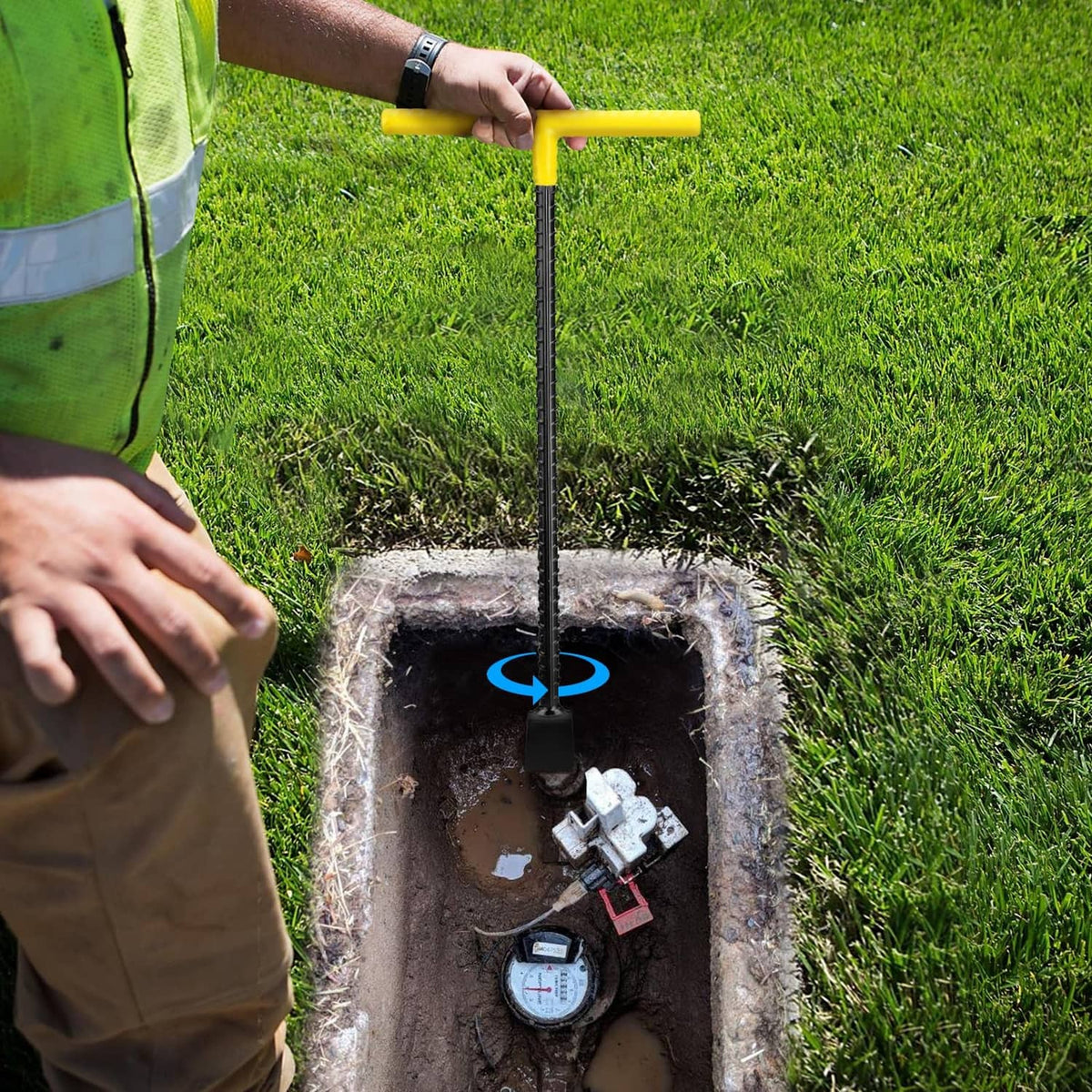 Water meter shut-off key held above an outdoor valve box opening