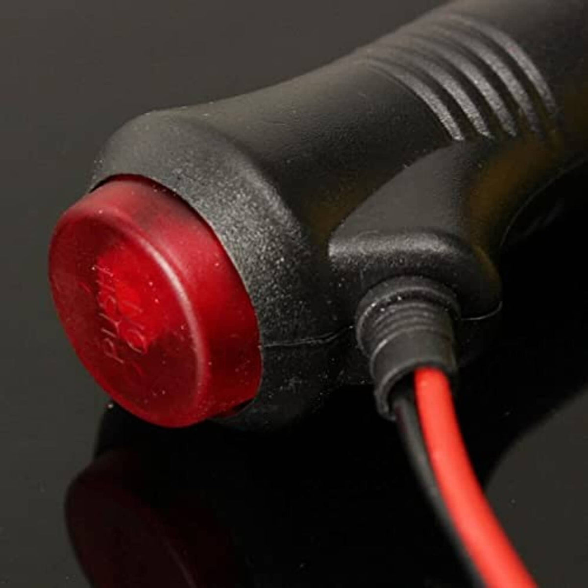 Red push-button indicator on 12V power plug with red wiring close-up