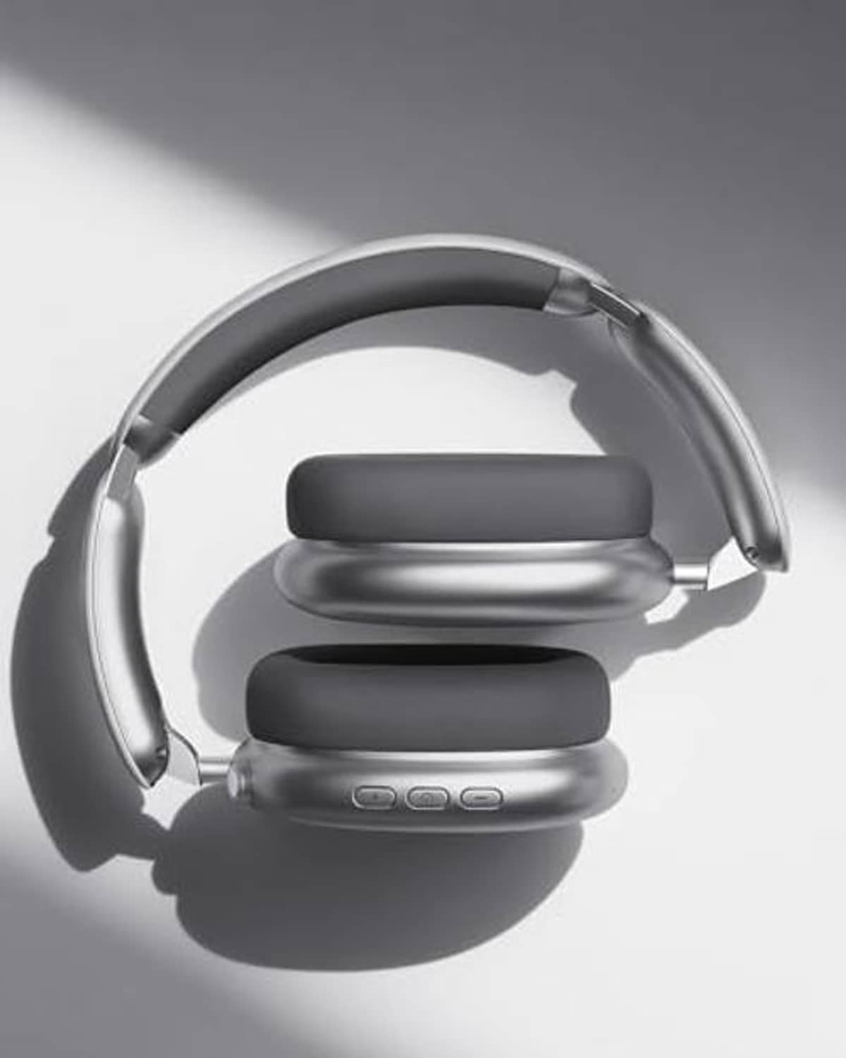Over-ear wireless headphones, grey headband and stacked dark ear cups, side view