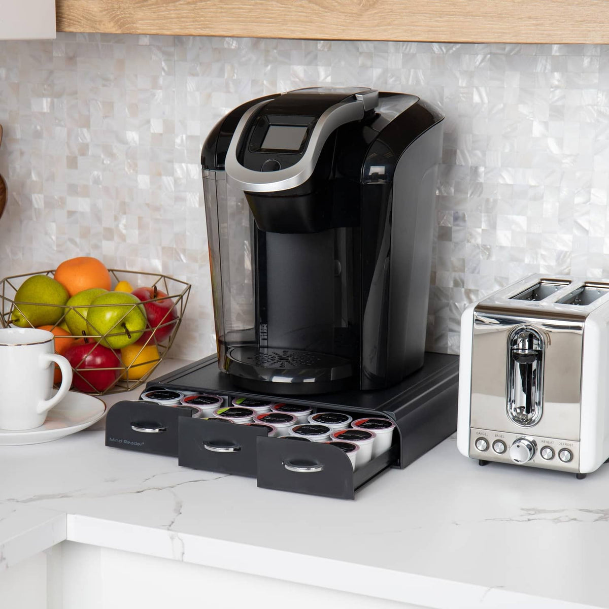 Black 3-drawer coffee pod organizer with open compartments holding assorted pod sleeves