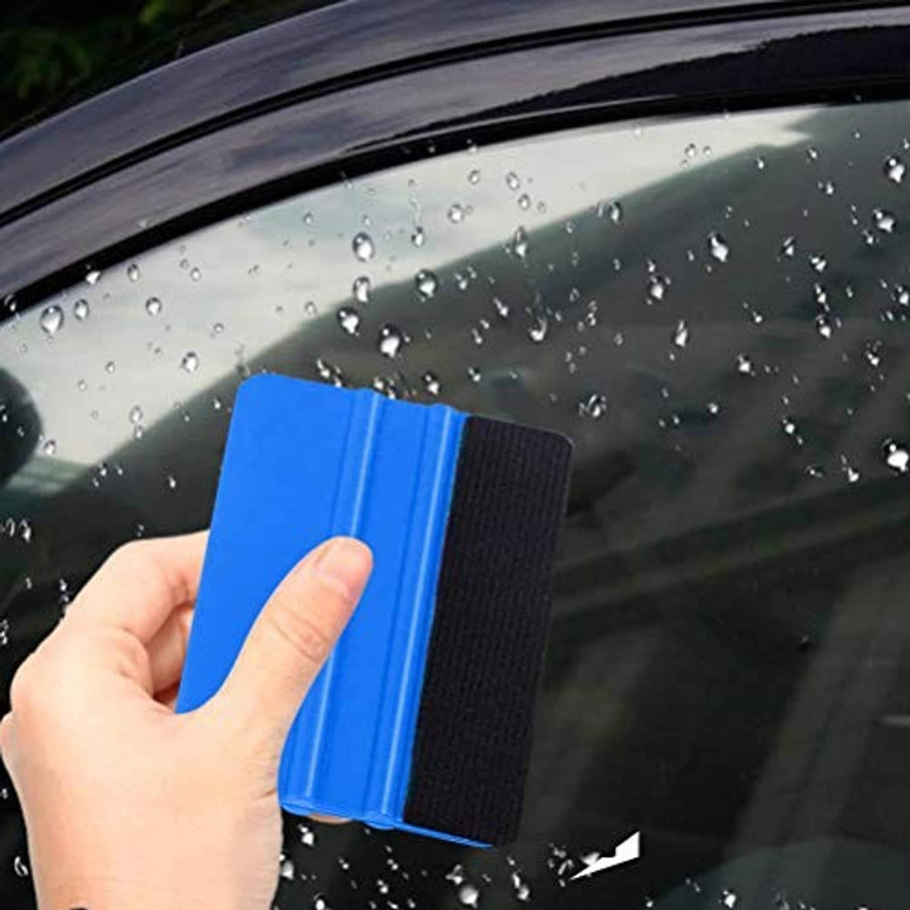 Blue felt edge squeegee tool with black backing, hand pressing on glass for vinyl scraping