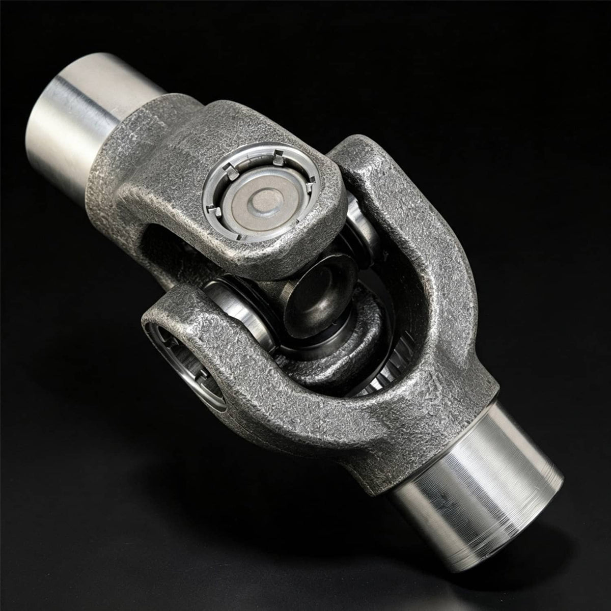 U-joint yoke joint with visible cross joint and two metal drive shafts