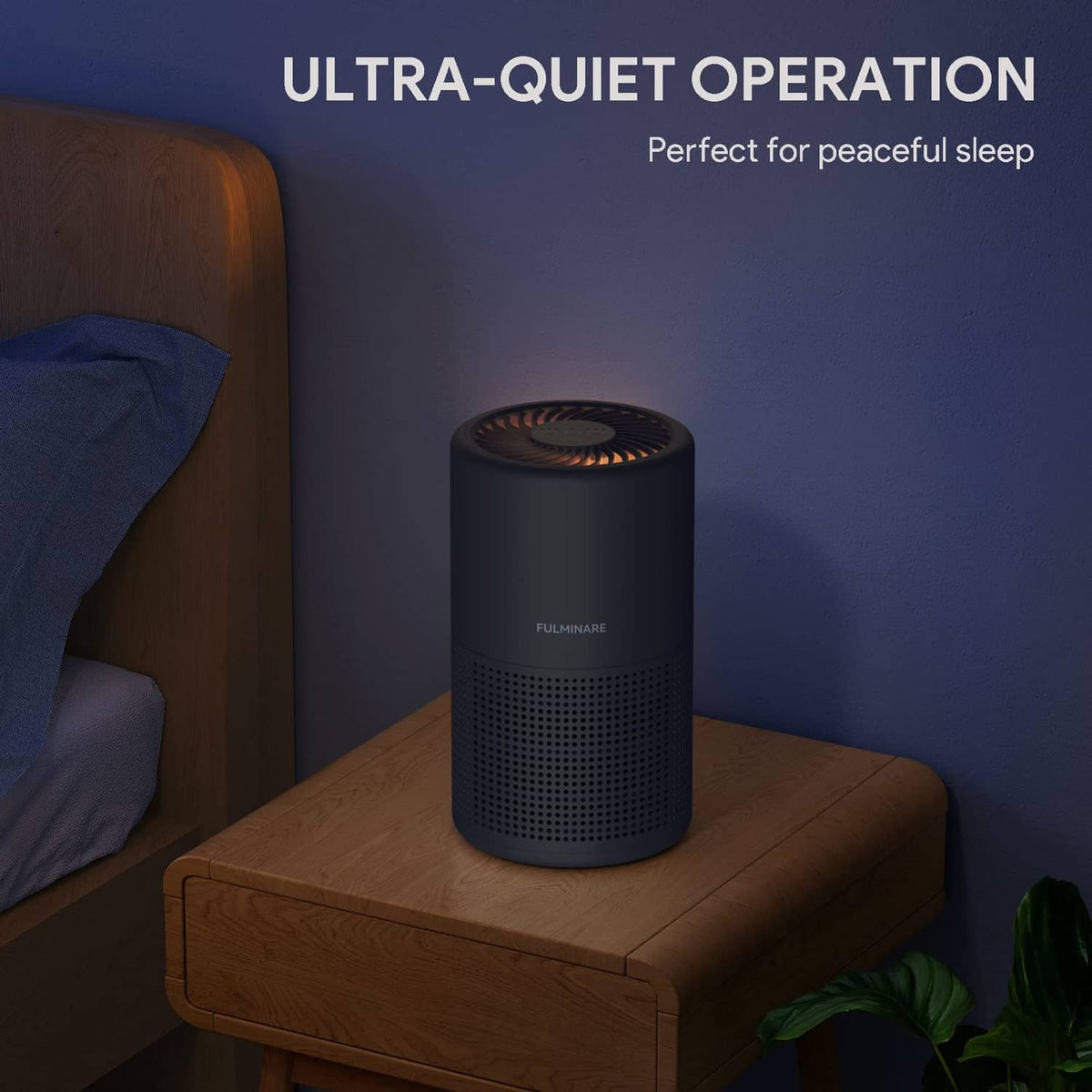 Black air purifier cylinder on a wooden nightstand with front perforation grille visible