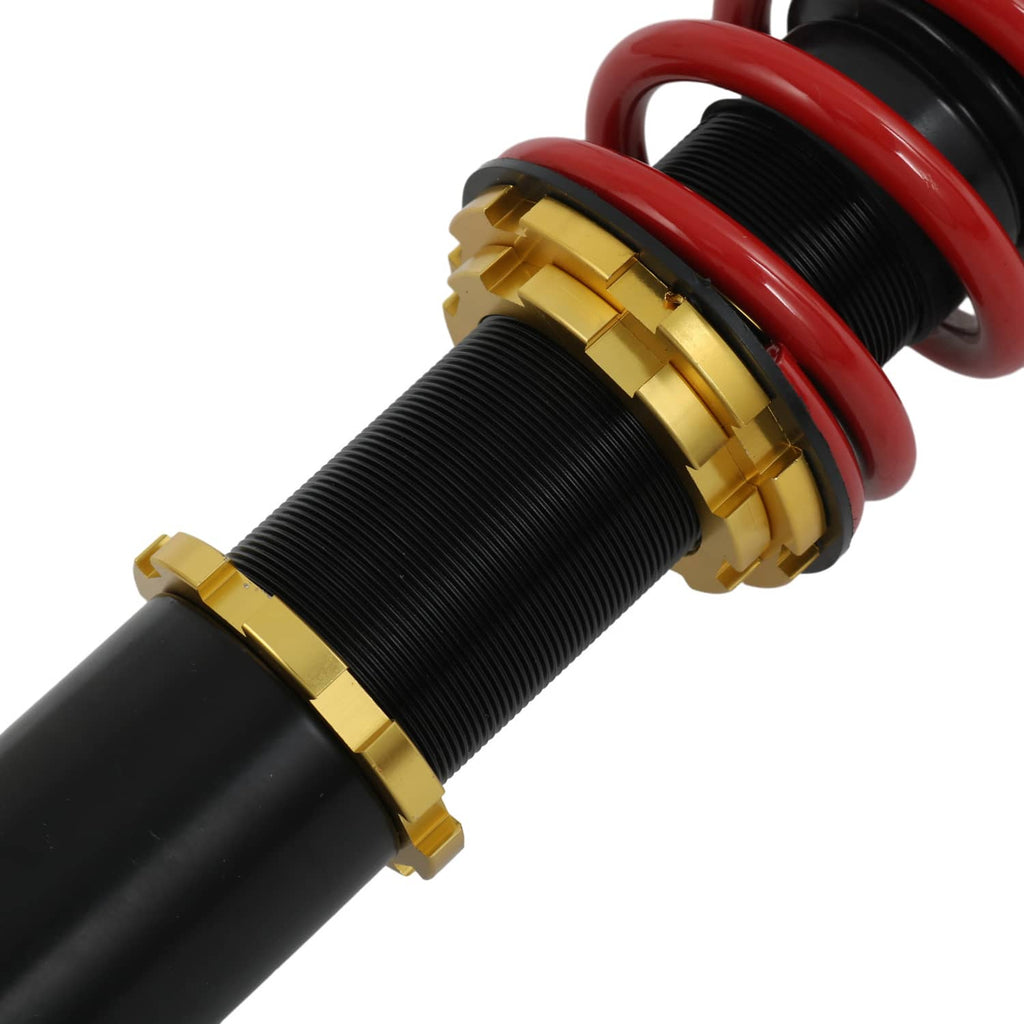 Close-up coilover spring assembly with red coils on black strut and gold adjustment ring