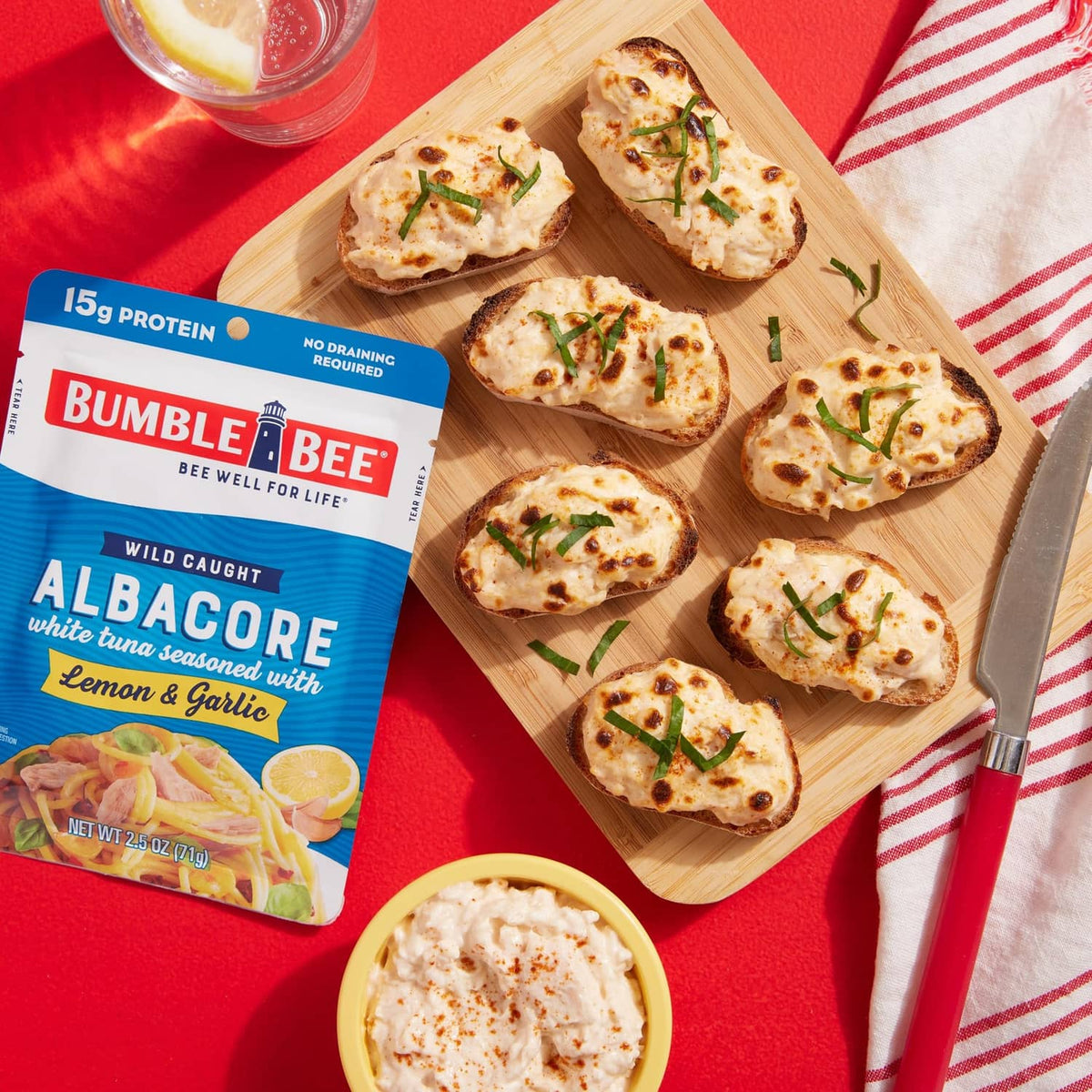 Albacore lemon and garlic tuna with crackers on a wooden serving board