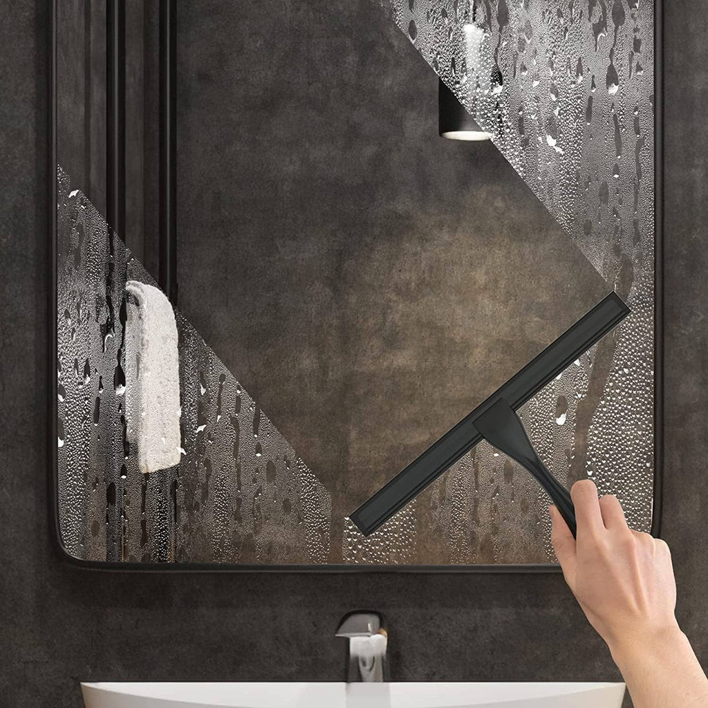Black shower glass squeegee used on a wet shower panel and wall surface.