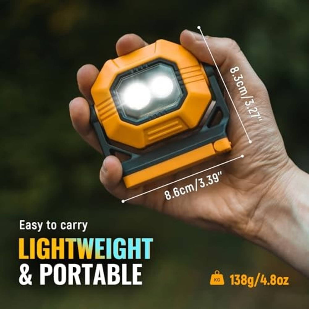 Orange and black compact rechargeable work light held in hand, small portable design