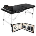 Black lash extension bed with padded sections, folding legs, and travel storage case