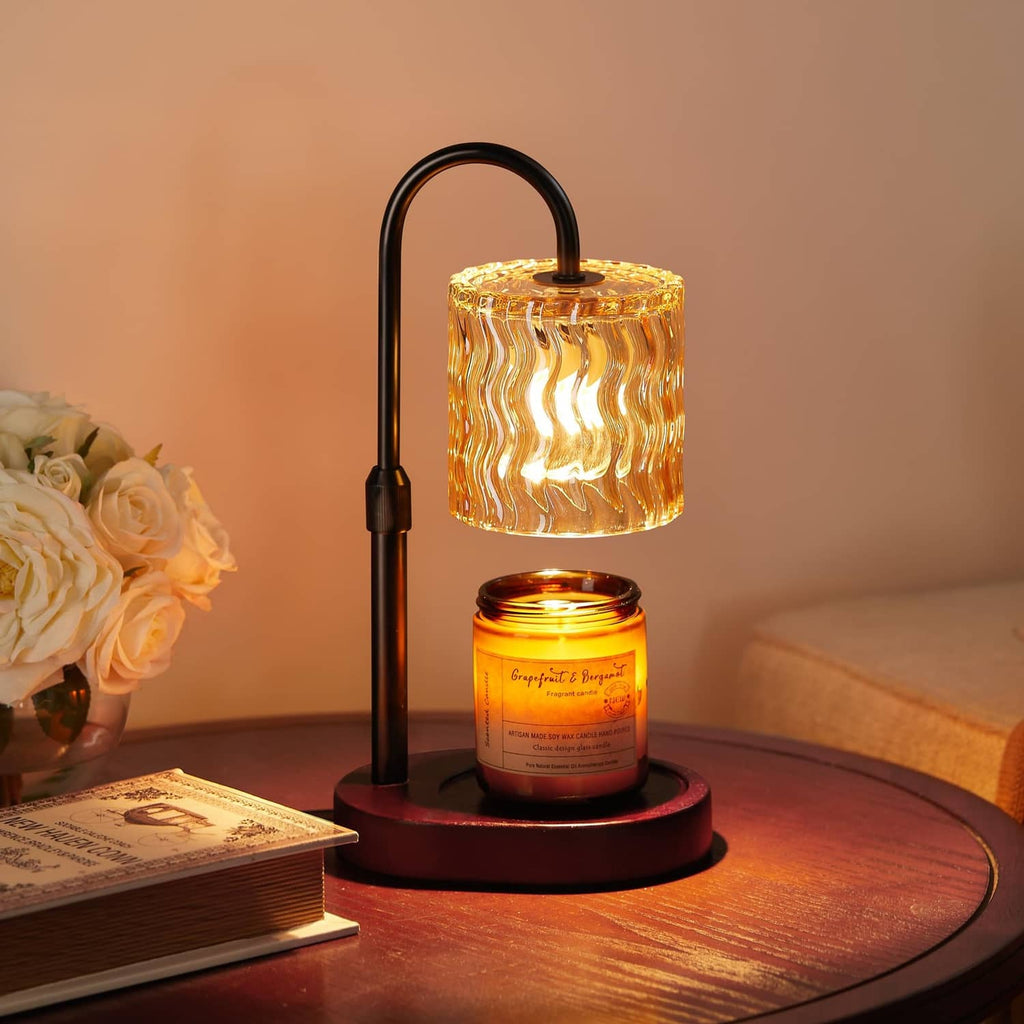Black candle warmer lamp with glowing glass lantern shade and round base