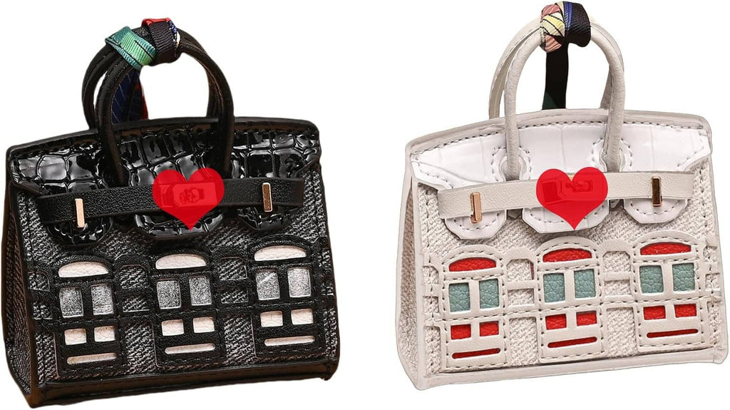 Black mini backpack keychain pouch with heart charm and white building print.