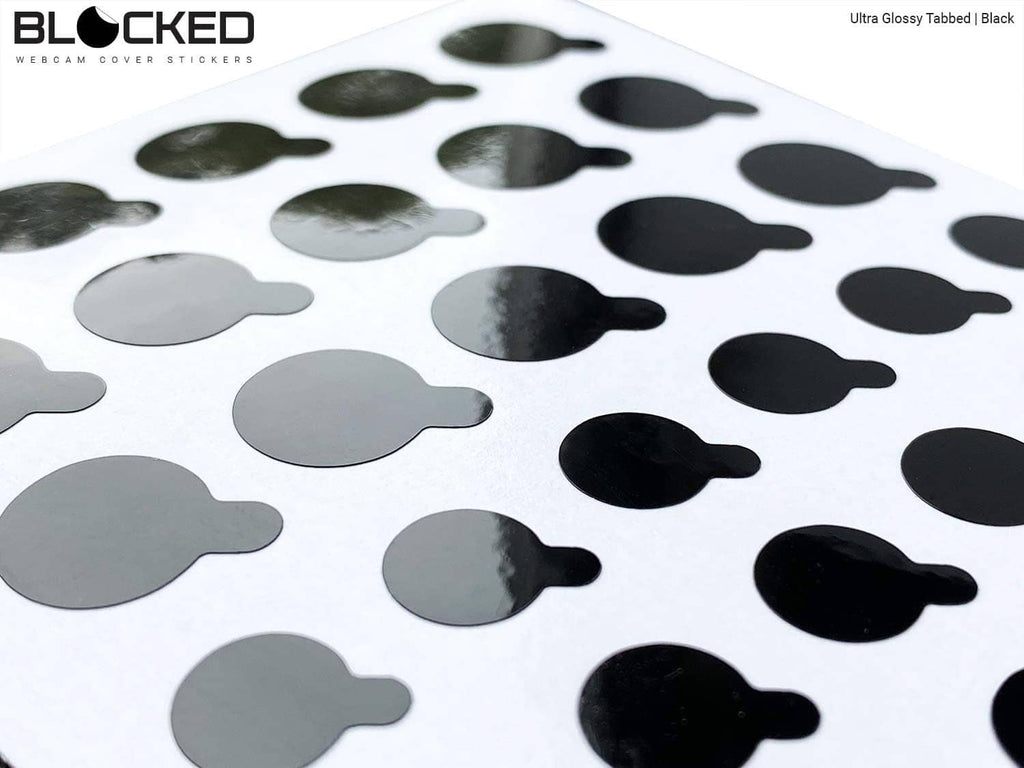 Close-up of black glossy tabbed privacy stickers arranged in a grid on the sheet