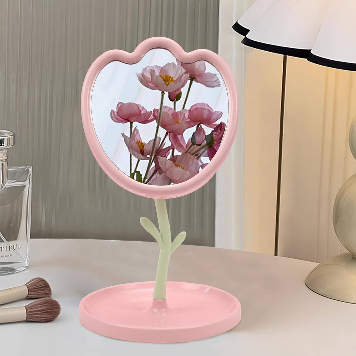 Pink flower-shaped tabletop mirror with round base and floral reflection