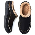 Black fuzzy moccasin slippers with plush lining and chain-stitched trim, side view