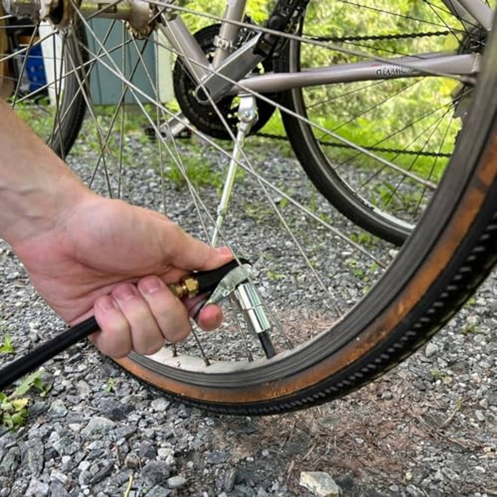 90-degree air chuck dispensing from valve on bicycle tire; metal nozzle and hose