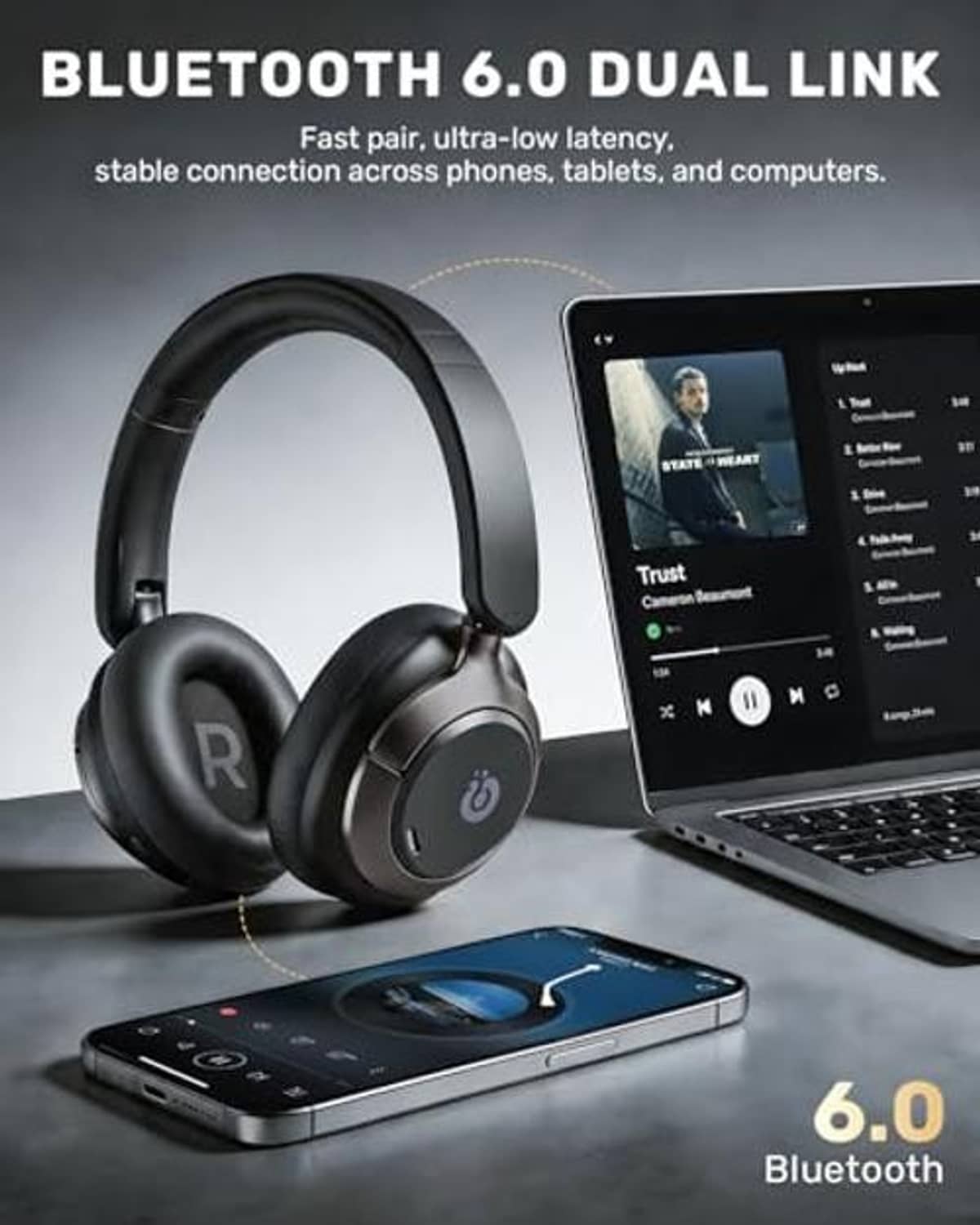 Over-ear black wireless headphones with Bluetooth 6.0 near phone and laptop