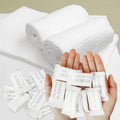 White compressed disposable towels, rolled stack with individual wrapped packets