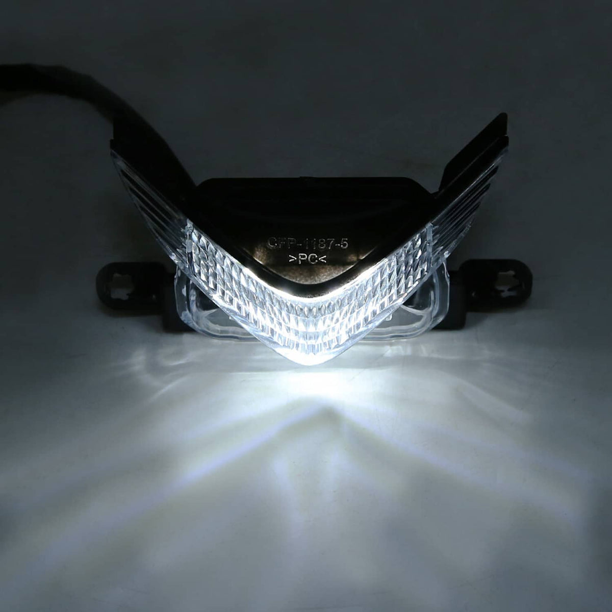 Lit front motorcycle headlight assembly with clear lens and black cover, chrome housing