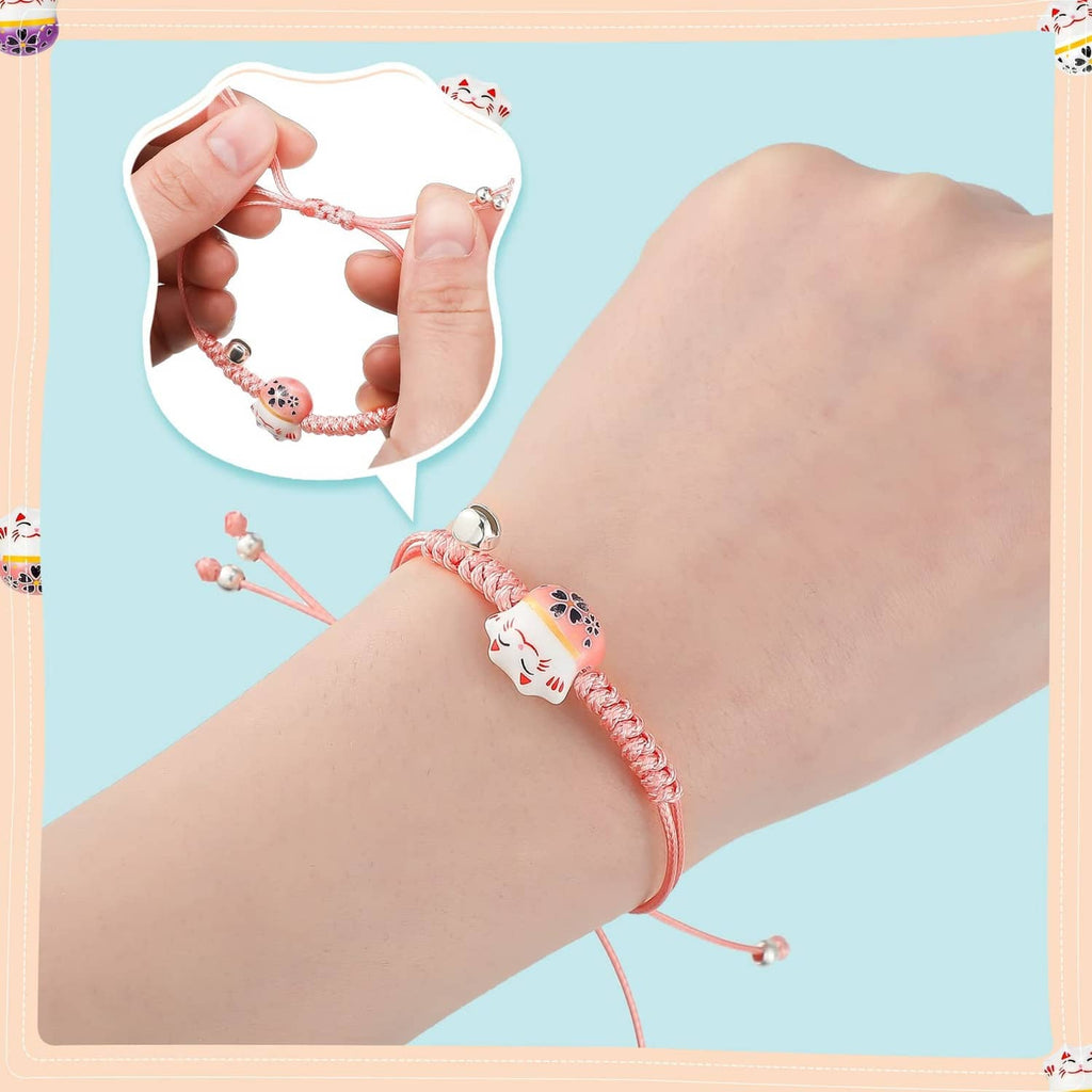Close-up of a braided lucky cat charm bracelet in pink-red with adjustable sliding knots