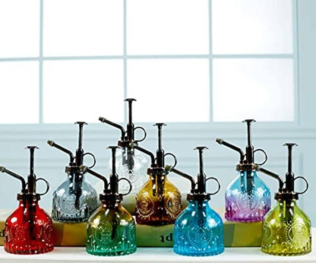 Set of vintage glass plant mister spray bottles with black pumps in colorful glass.