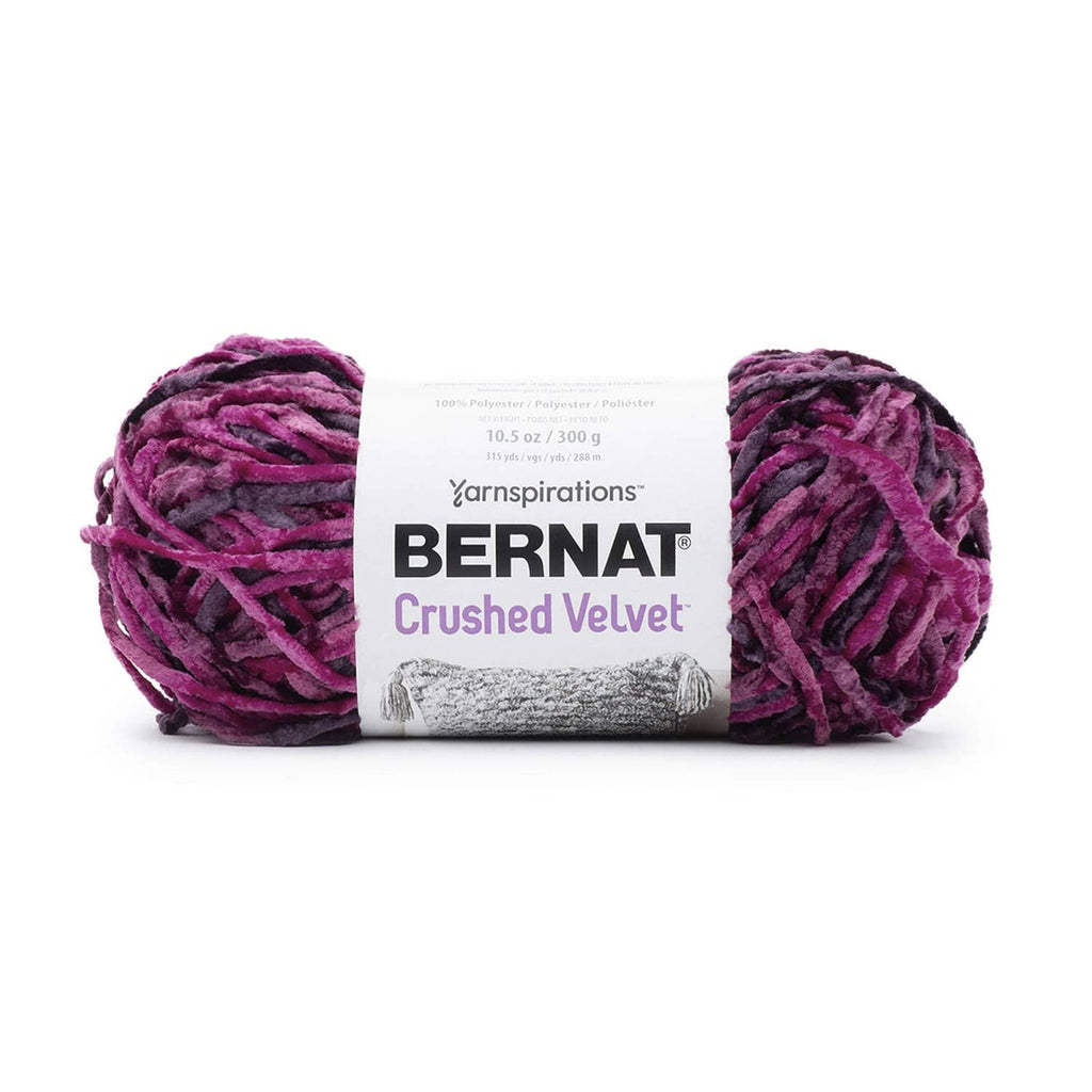 Bright magenta crushed velvet yarn skeins with wrapped label, bulky weight.