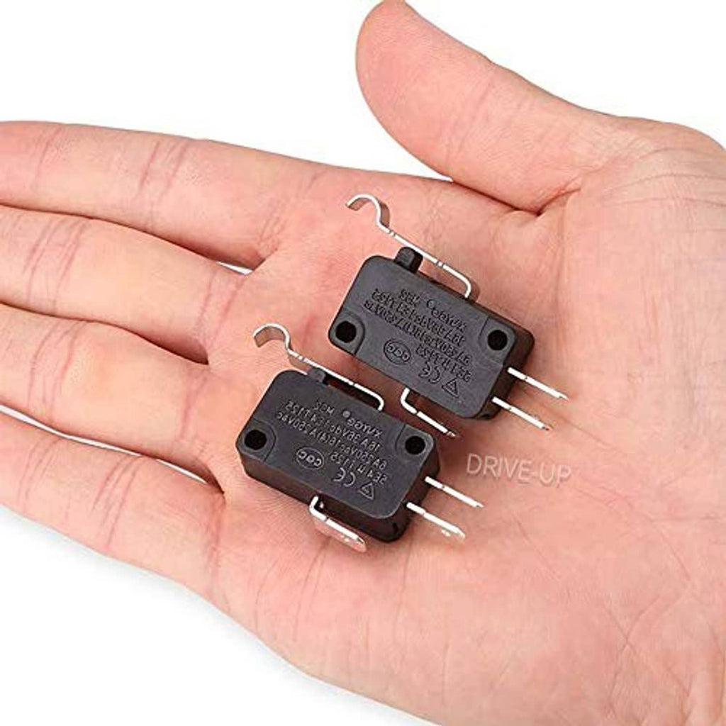 Black micro switches with lever and metal prongs held in a person’s hand