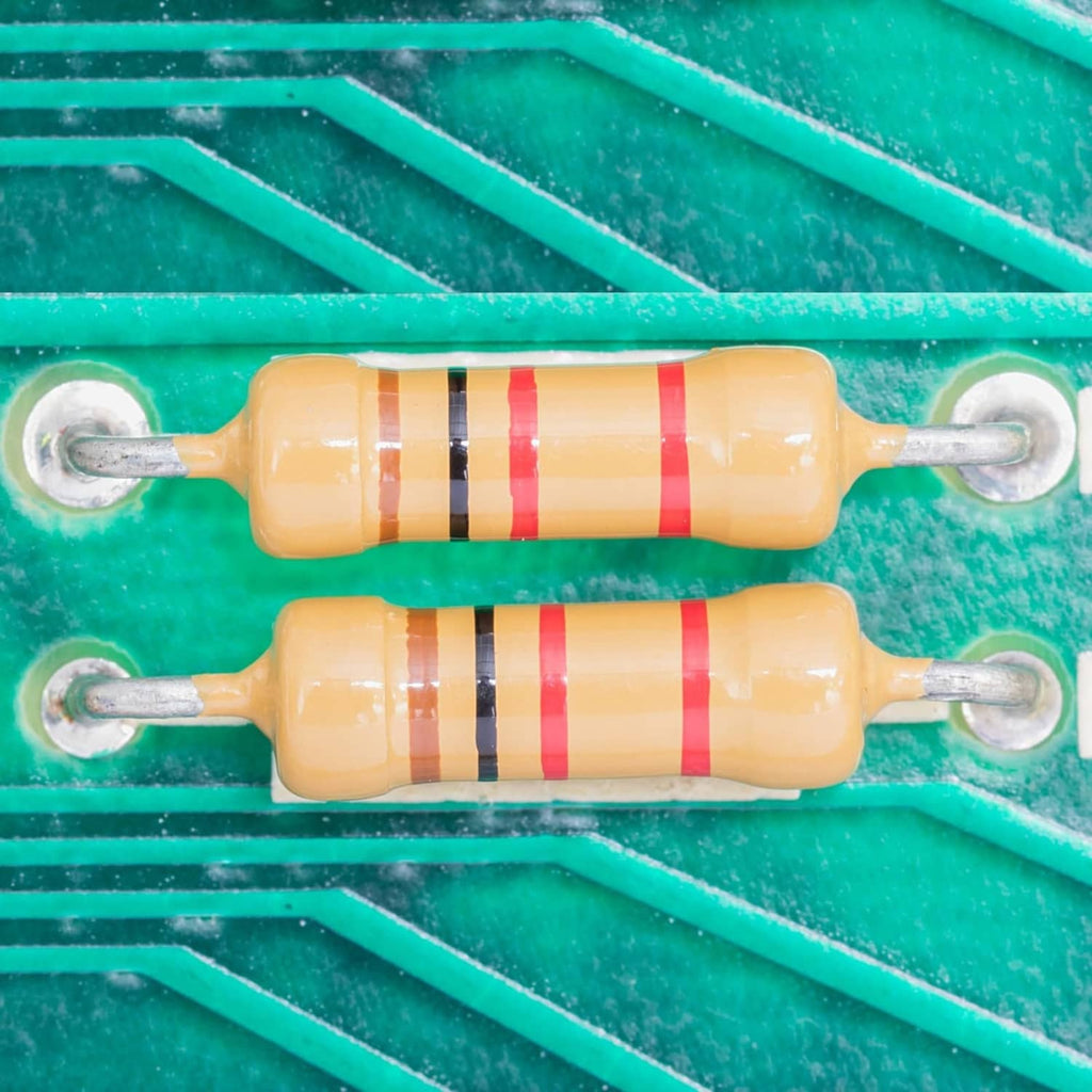 Close-up of axial lead resistors with colored band markings on light body