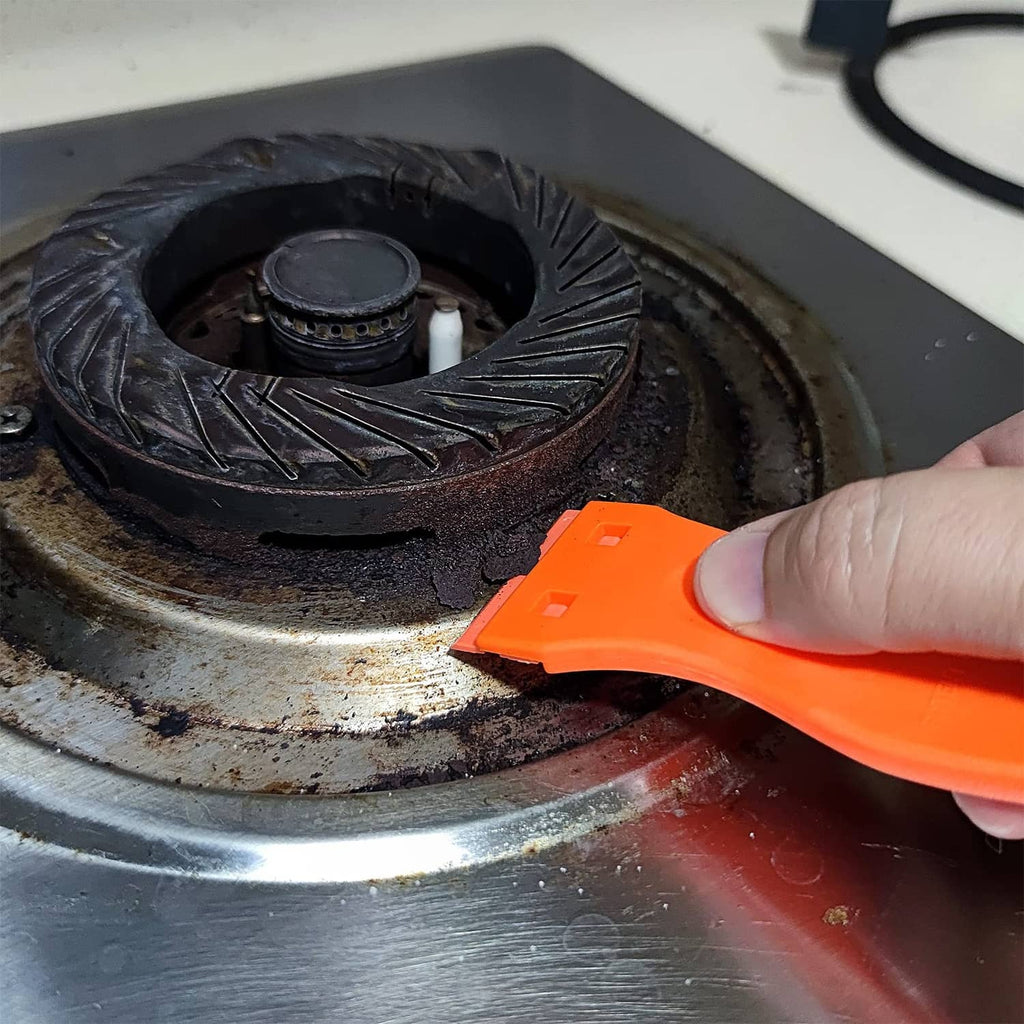 Orange plastic razor blade tool used to scrape a metal surface