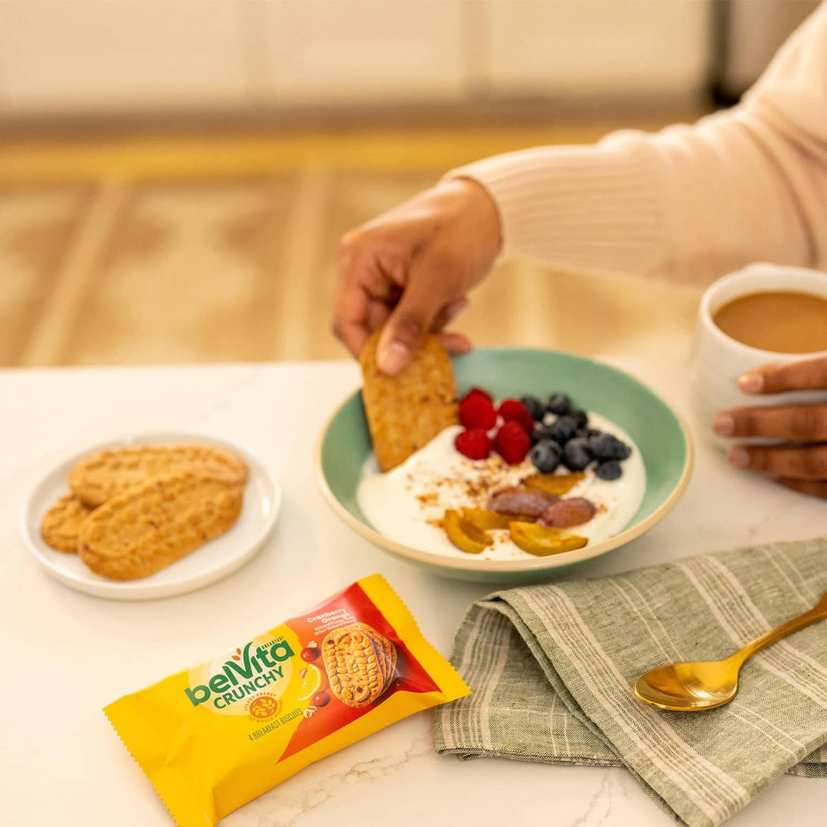 Belvita Crunchy cranberry-orange breakfast biscuits pack on breakfast table with food
