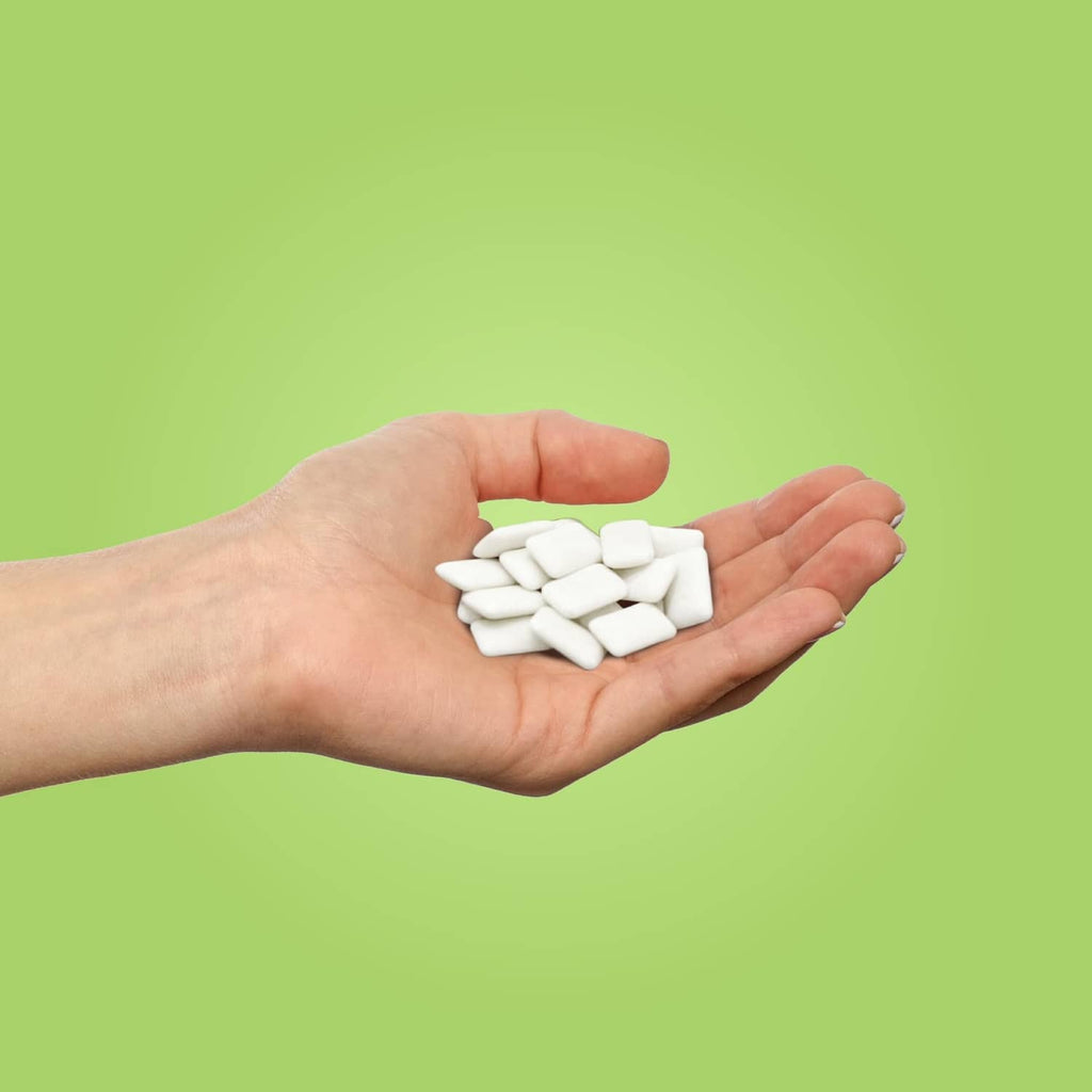 Coolmint xylitol gum pieces held in a hand